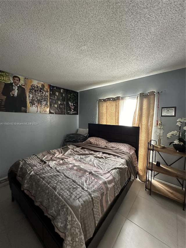 bedroom with a textured ceiling, ceiling fan, and light tile flooring