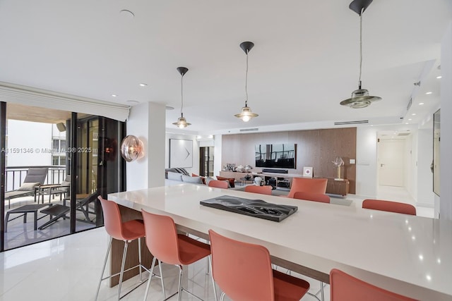 kitchen featuring open floor plan, hanging light fixtures, expansive windows, light countertops, and recessed lighting