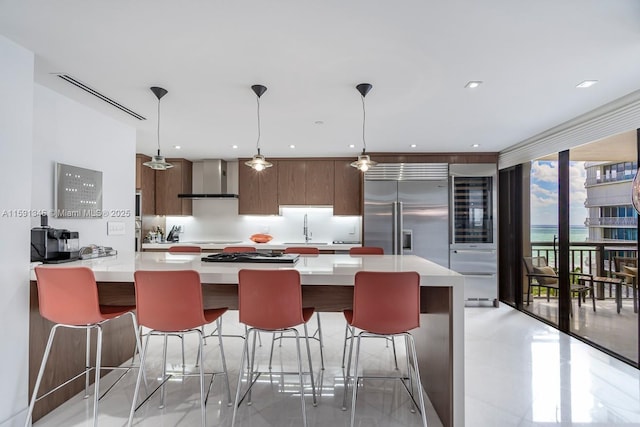 kitchen featuring built in fridge, a sink, light countertops, wall chimney exhaust hood, and modern cabinets