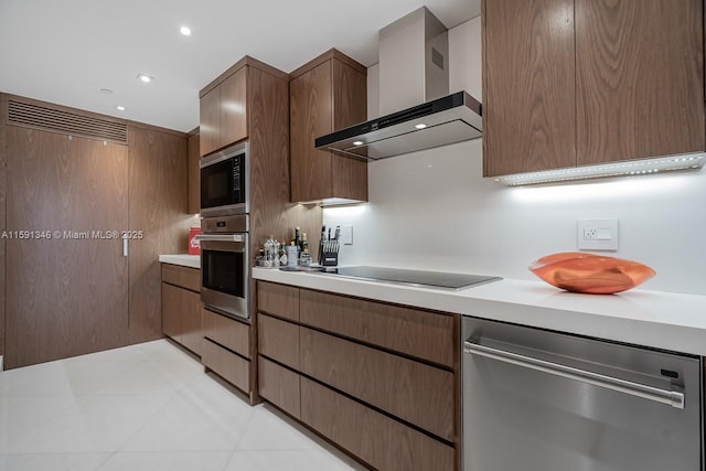 kitchen with light countertops, wall chimney range hood, appliances with stainless steel finishes, and recessed lighting