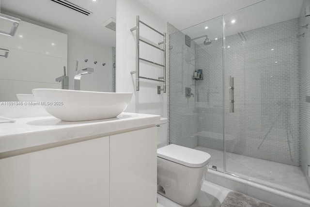 full bathroom featuring vanity, a shower stall, and toilet