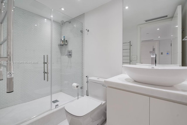 bathroom with visible vents, a shower stall, toilet, and vanity