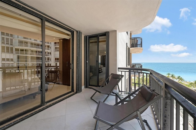 balcony with a water view and a view of the beach