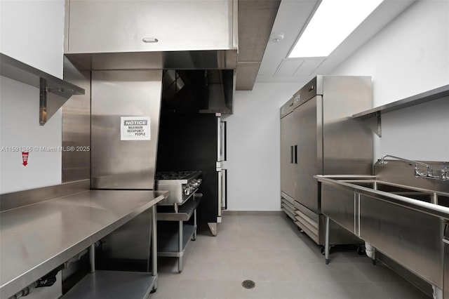 kitchen featuring stainless steel countertops, stainless steel fridge, and a sink