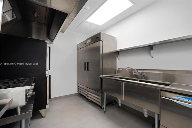 kitchen with light tile patterned floors, baseboards, and stainless steel refrigerator