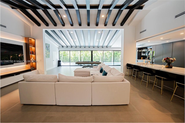 living room with high vaulted ceiling, beamed ceiling, sink, and light tile flooring