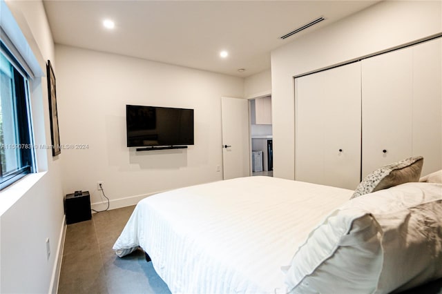 bedroom with a closet and dark tile floors