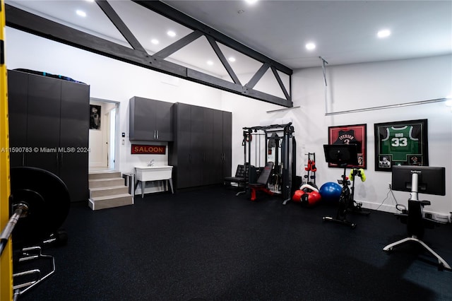 exercise room featuring a towering ceiling