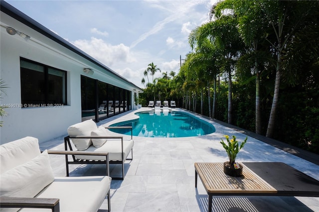 view of pool with a patio and an outdoor living space