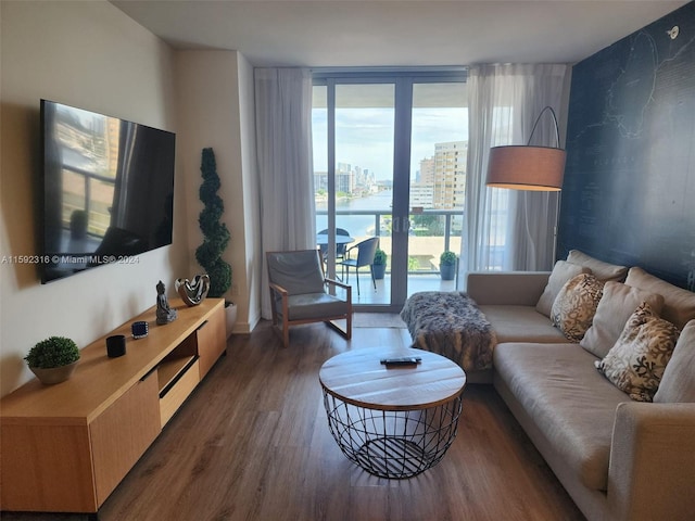 living room with a wall of windows, dark hardwood / wood-style floors, and a water view