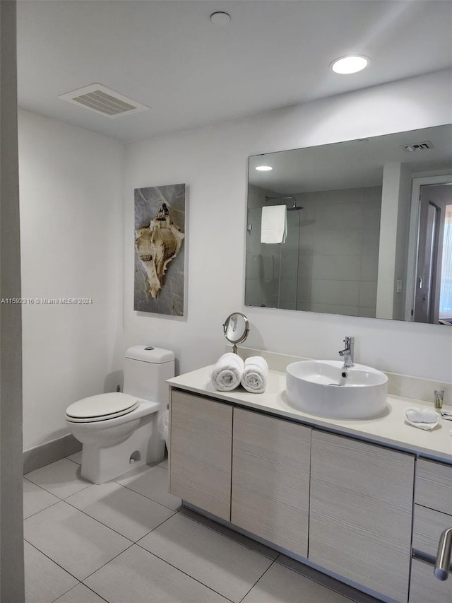 bathroom featuring toilet, a shower, tile patterned floors, and vanity