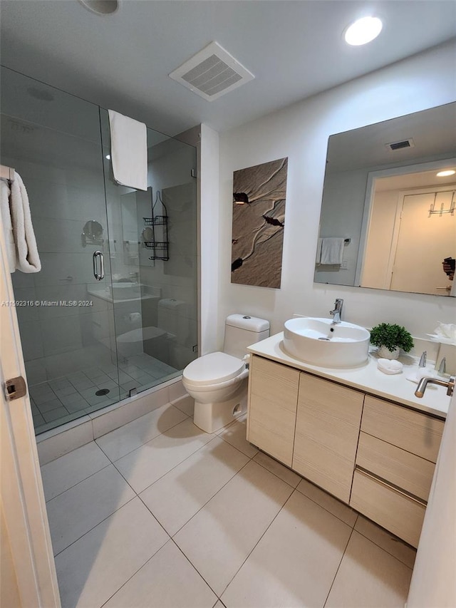 bathroom featuring a shower with door, tile patterned floors, vanity, and toilet