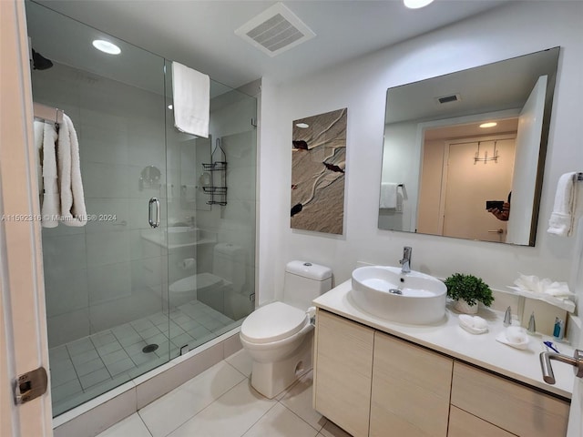 bathroom with toilet, vanity, tile patterned flooring, and a shower with shower door