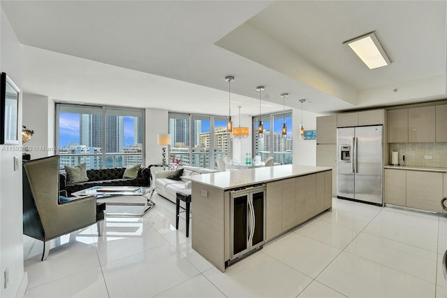 kitchen featuring decorative light fixtures, stainless steel fridge with ice dispenser, light tile patterned floors, beverage cooler, and decorative backsplash