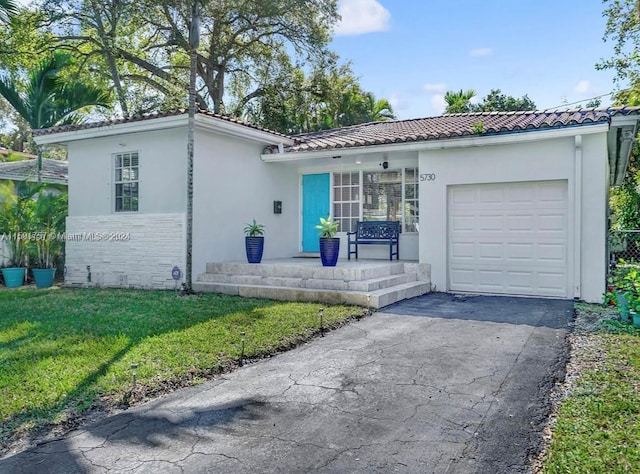 view of front of house featuring a front lawn and a garage