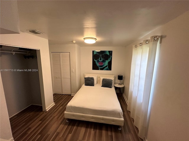 bedroom with dark hardwood / wood-style flooring and a closet