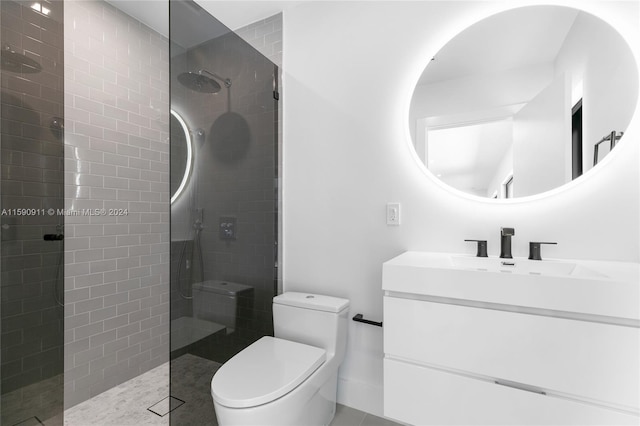 bathroom with toilet, vanity, tile patterned floors, and a tile shower