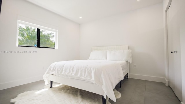 bedroom featuring concrete floors and a closet