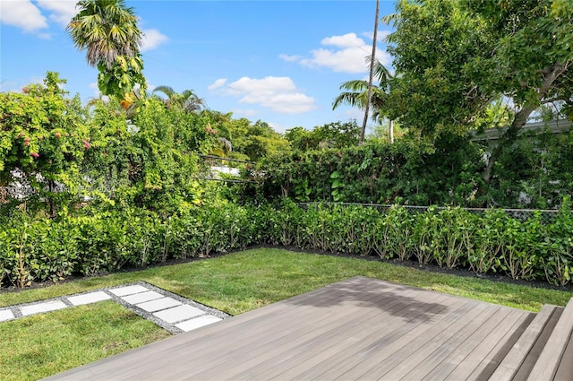 wooden deck featuring a lawn