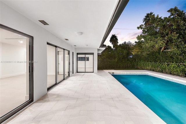 pool at dusk with a patio