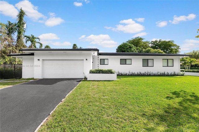 view of front of property with a front lawn and a garage