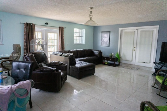 tiled living room featuring a textured ceiling and french doors