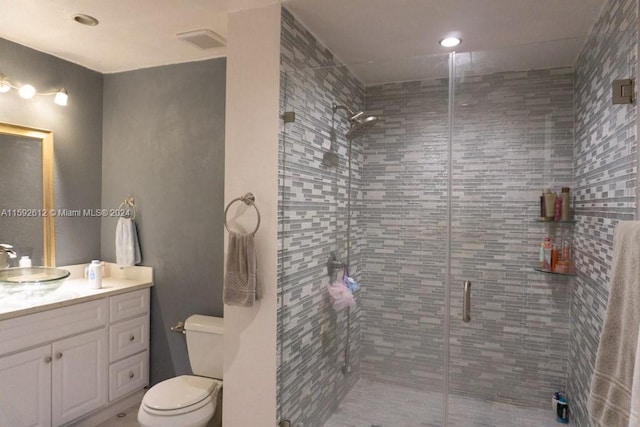 bathroom featuring an enclosed shower, vanity, and toilet