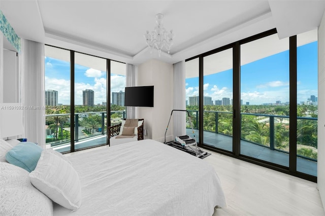 bedroom featuring multiple windows, access to exterior, and a chandelier