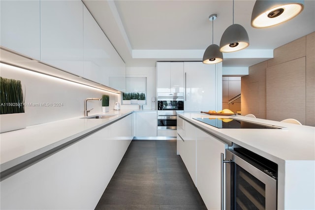 kitchen with wine cooler, pendant lighting, sink, white cabinetry, and double oven