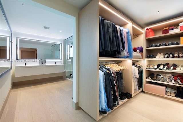 walk in closet with light wood-type flooring