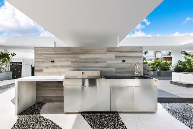 view of patio / terrace featuring sink, a wooden deck, and an outdoor kitchen