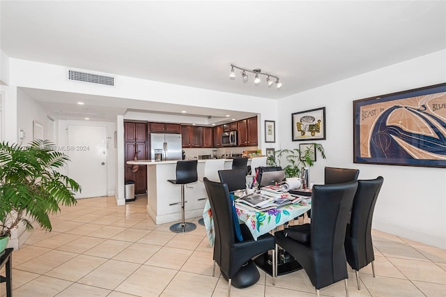 tiled dining space featuring rail lighting