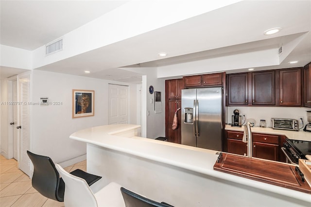 kitchen with stainless steel fridge, dark brown cabinets, light tile floors, and black electric range oven