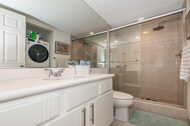 bathroom featuring tile flooring, stacked washing maching and dryer, an enclosed shower, toilet, and large vanity