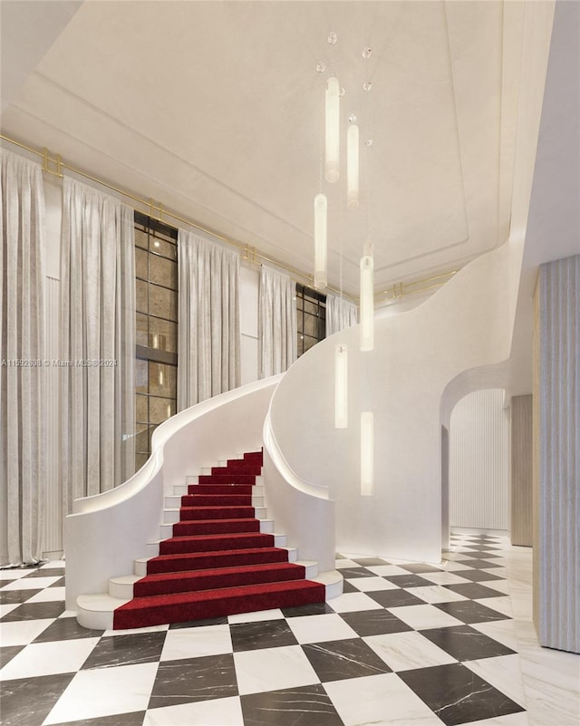 stairway featuring tile flooring and a towering ceiling