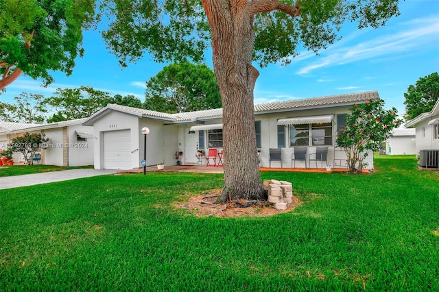 single story home with a garage, a front yard, and central AC unit