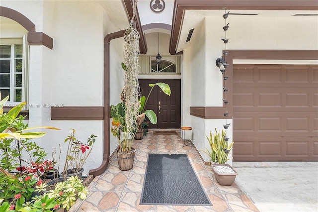 entrance to property featuring a garage and stucco siding