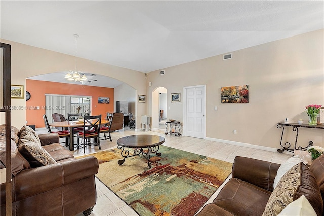 living area featuring arched walkways, lofted ceiling, light tile patterned flooring, and visible vents