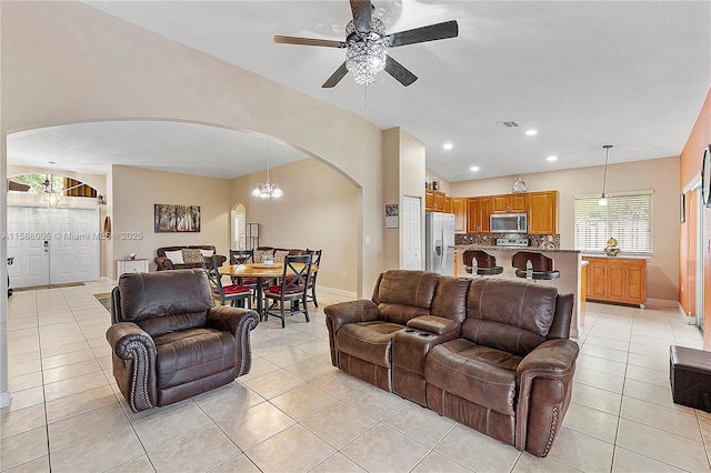 living room with arched walkways, light tile patterned floors, and a wealth of natural light