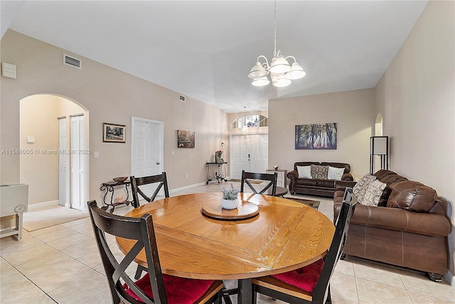 dining area featuring arched walkways, light tile patterned floors, visible vents, and a notable chandelier