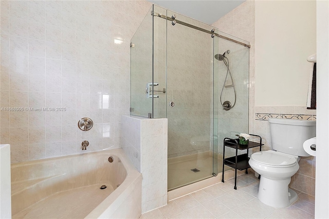 full bathroom featuring tile patterned flooring, toilet, a garden tub, tile walls, and a shower stall