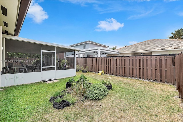 view of yard featuring a fenced backyard and a sunroom