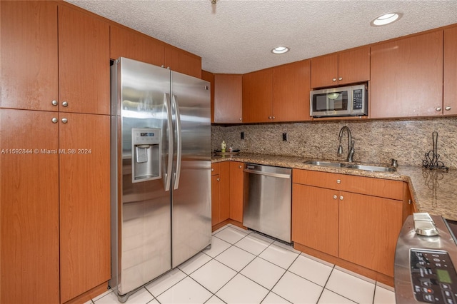 kitchen with stainless steel appliances, sink, light tile flooring, and backsplash