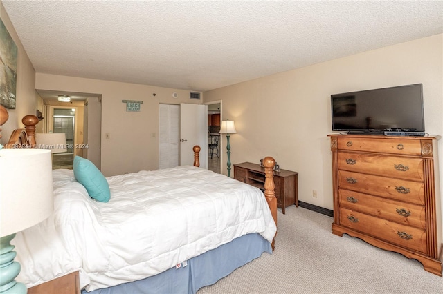 bedroom with a closet, a textured ceiling, and light colored carpet