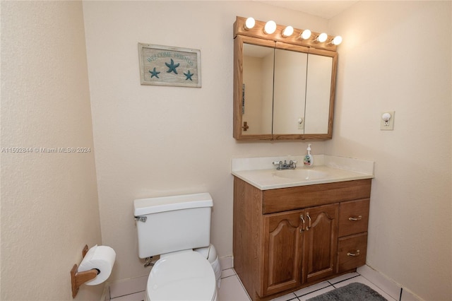 bathroom with tile flooring, vanity with extensive cabinet space, and toilet