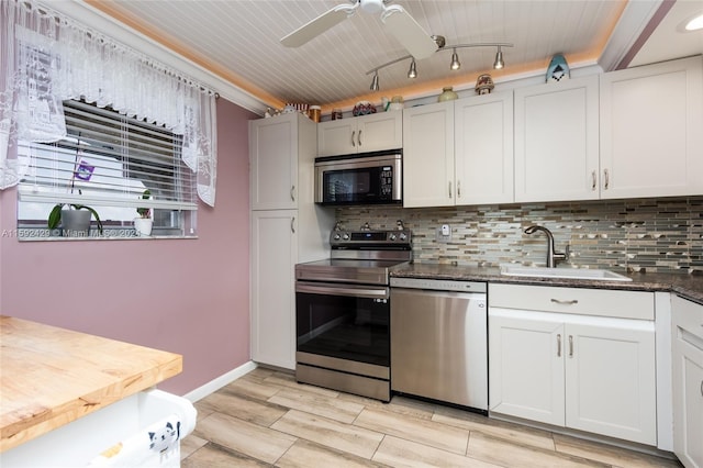 kitchen with appliances with stainless steel finishes, sink, backsplash, and ceiling fan