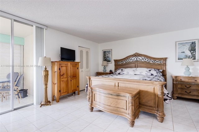 tiled bedroom with access to outside and a textured ceiling