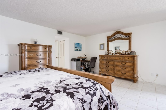 tiled bedroom featuring a textured ceiling