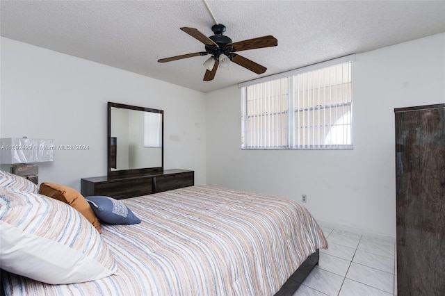 bedroom with a textured ceiling, ceiling fan, and light tile floors