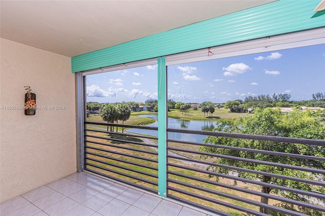 sunroom featuring a water view